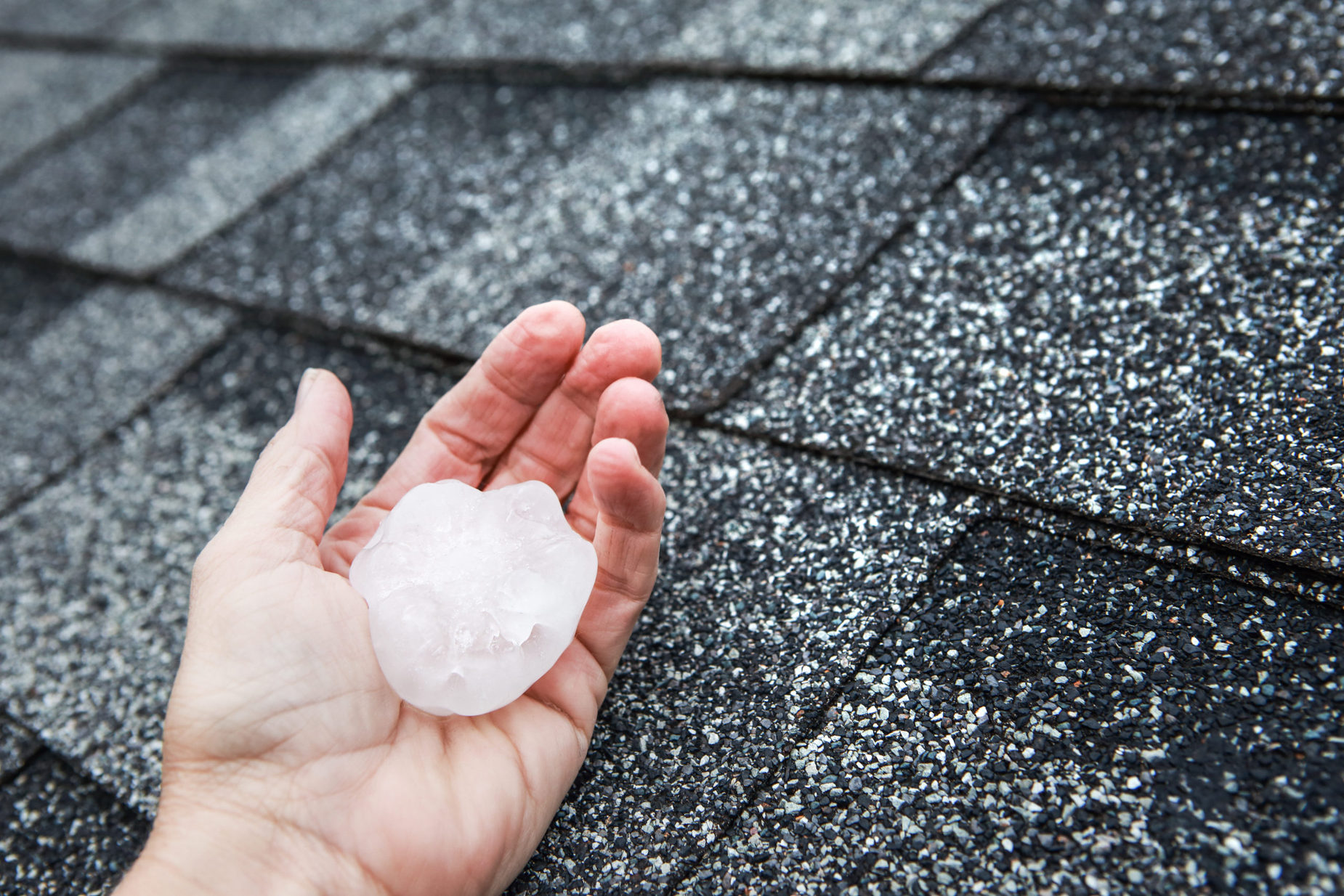 A hand holding a piece of hail